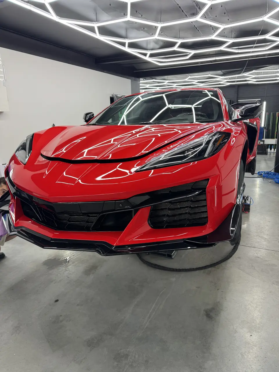 Czerwony Chevrolet Corvette C8 pod lampą do kontroli lakieru w Redlines