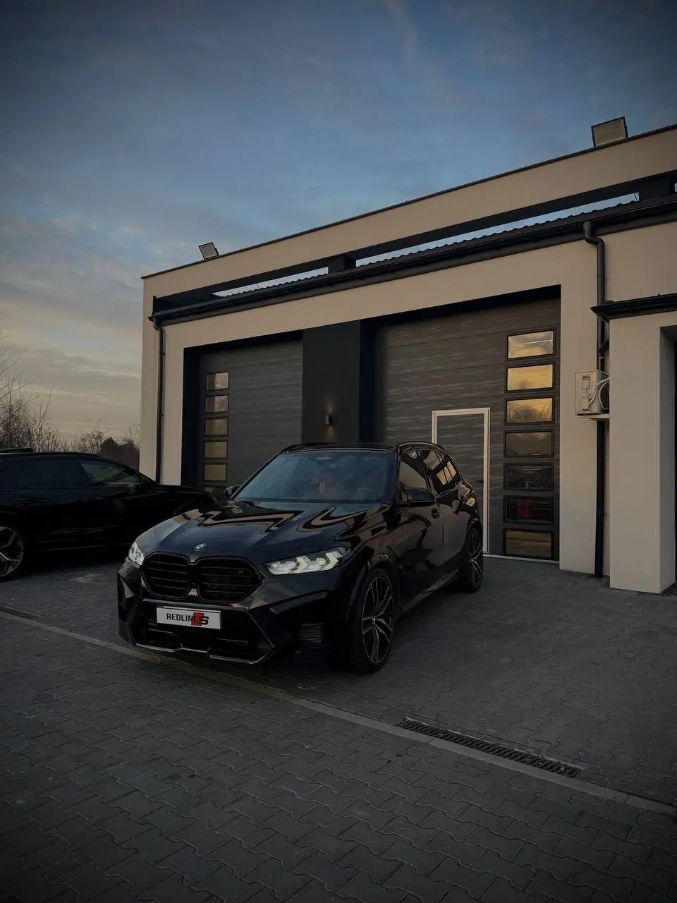 Siedziba Redlines Car Service o zmierzchu z BMW X5 M przed wejściem