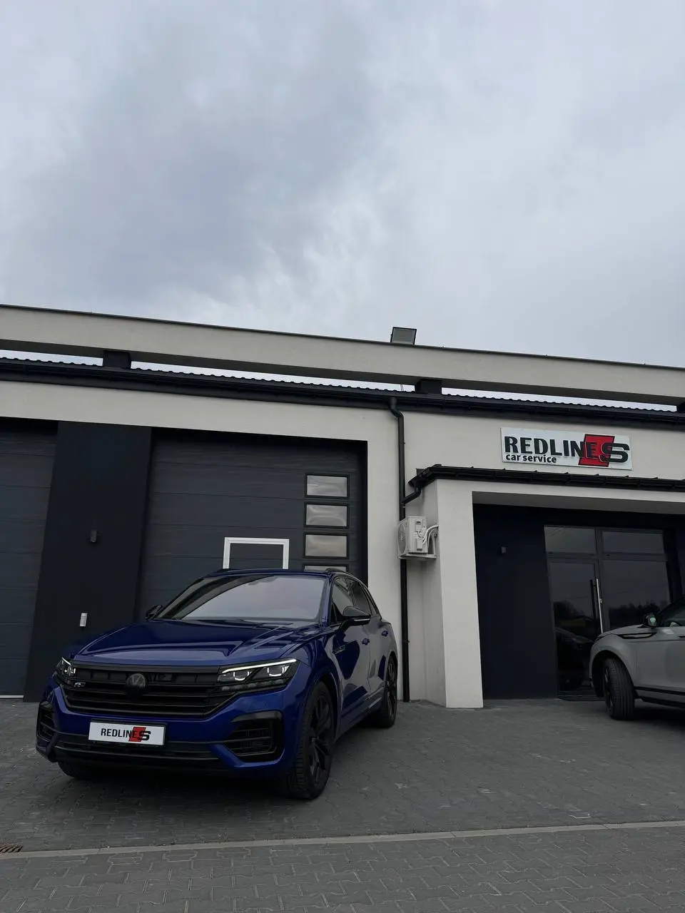 Granatowy Volkswagen Touareg R przed warsztatem Redlines